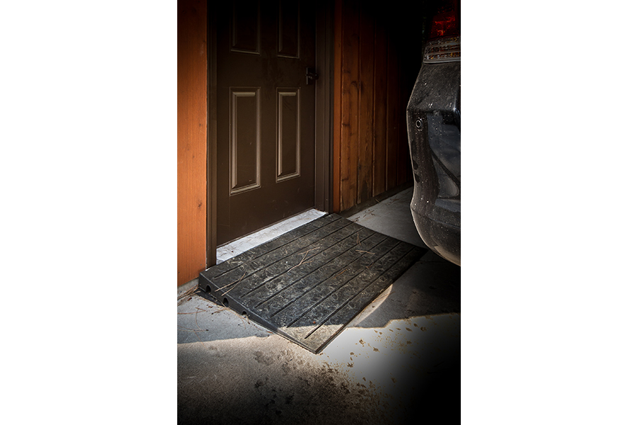 A small, black rubber wedge turns a door with a several-inch ledge into a zero-step accessible entrance.